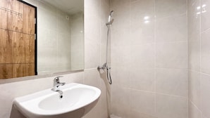 A bathroom with a white sink, a mirror, and a shower.