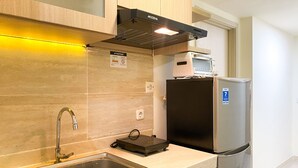 A kitchen with a stainless steel sink, a built-in oven, and a refrigerator. - Best Spacious And Homey 2Br At Meikarta Apartment (Cikarang)