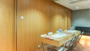 A conference room with a long table, chairs, and a water dispenser. - Good Deal And Comfortable 1Br The Boulevard Apartment (Jakarta)