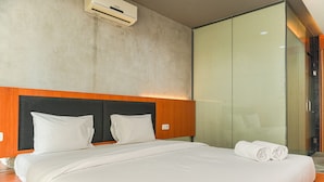 A modern hotel room with a large bed, a wooden headboard, and a glass partition. - Good Deal And Comfortable 1Br The Boulevard Apartment (Jakarta)