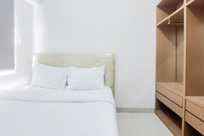 Ein Schlafzimmer mit einem Bett, einem Holzschrank und einem Fenster.