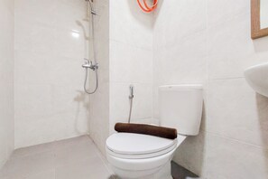 Ein kleines, sauberes Badezimmer mit Toilette, Dusche und Waschbecken.