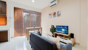 Ein modernes Wohnzimmer mit einer Couch, einem Fernseher und einer Schiebetür.