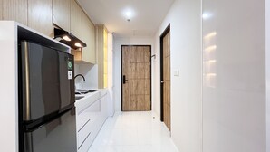 A modern kitchen with a refrigerator, stove, and wooden cabinets.