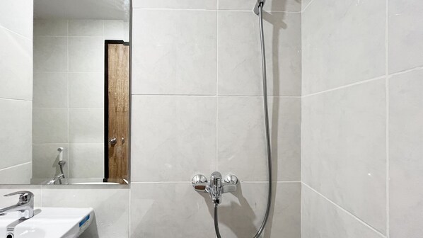 A bathroom with a shower, a sink, and a mirror.