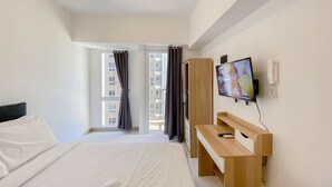 A hotel room with a bed, a desk, a TV, and a window with curtains. - Brand New Studio For 4 Pax At Tokyo Riverside Pik 2 Apartment (Teluknaga)