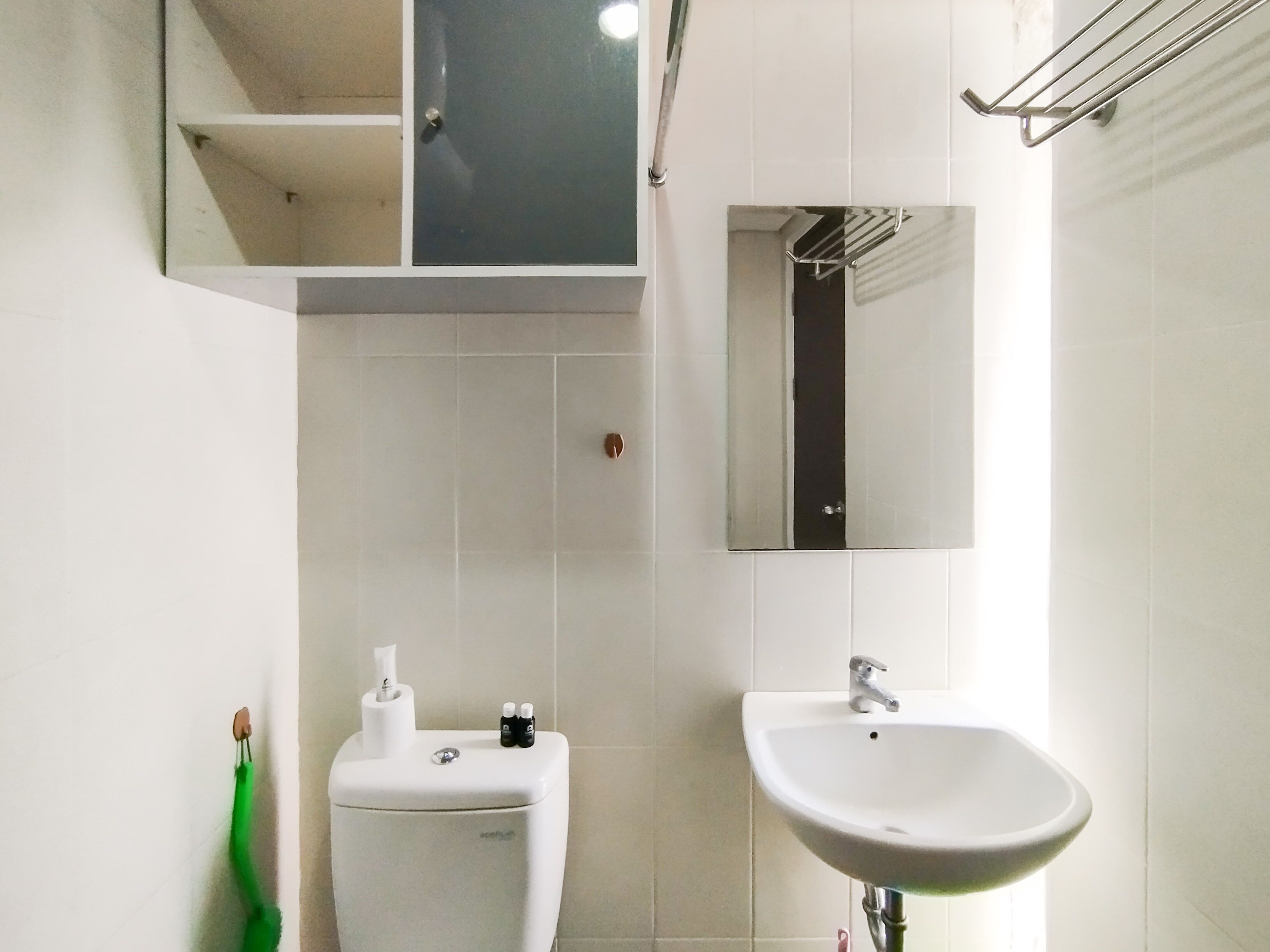 Une salle de bain avec des toilettes, un lavabo et un miroir.