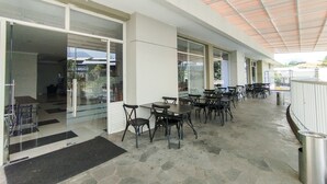 An outdoor patio area with stone flooring, tables, and chairs. - Strategic And Comfy Studio At Skyland City Jatinangor Apartment (Hegarmanah)