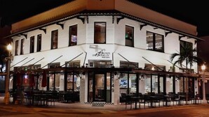 A corner building with a restaurant named 'Brooklyn's of Brooklyn' at night. - Black Brindle Cottage, Downtown Ft. Myers: Walk to Best Eats and Shops! (Fort Myers)