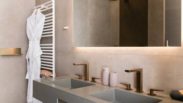Un baño moderno con dos lavamanos, un espejo grande y un perchero para toallas.