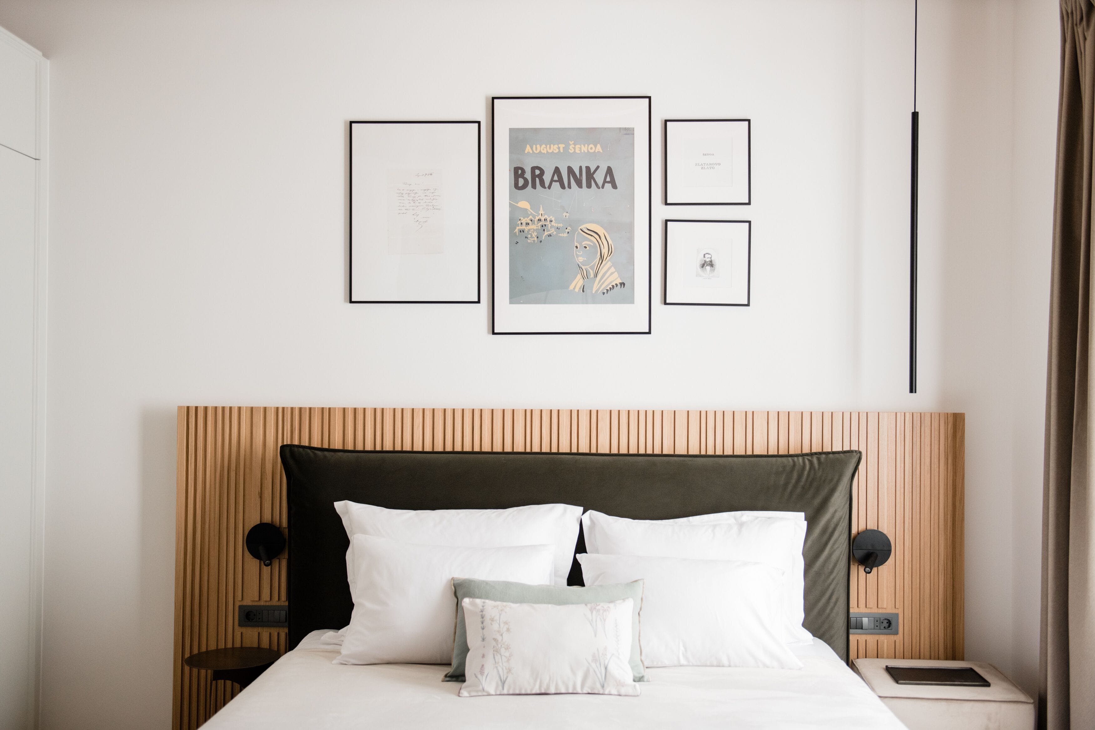 A neatly arranged hotel room with a bed, bedside tables, and framed artwork on the wall.