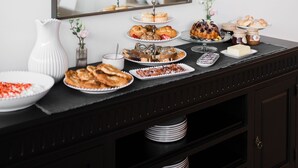 A buffet table with various dishes and a mirror reflecting the room. - Boutique HOH (Zagreb)