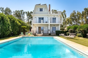 Une maison à deux étages avec une piscine à l’avant.