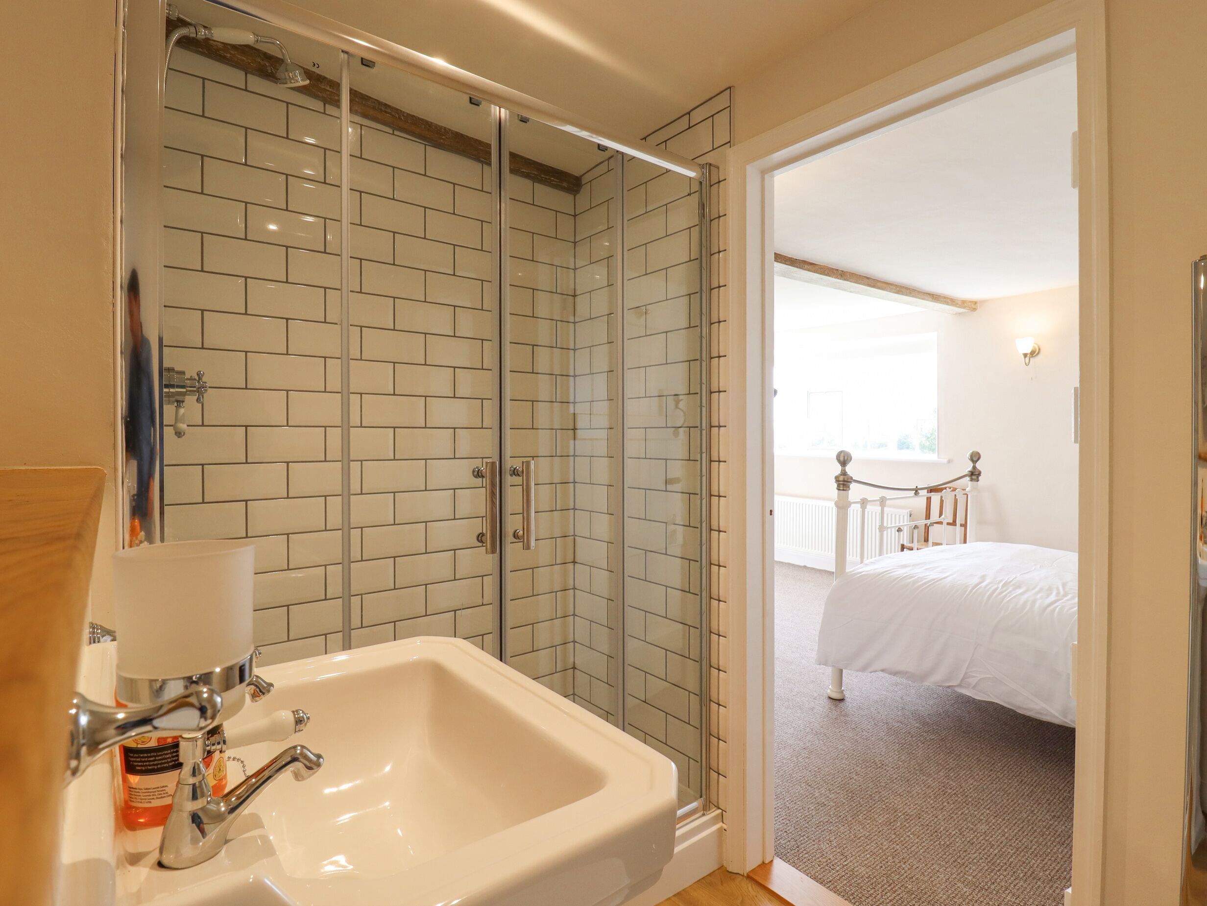 A bathroom with a white sink, a glass shower enclosure, and a white bathtub.