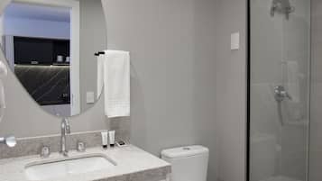 A modern bathroom with a sink, toilet, and glass-enclosed shower.