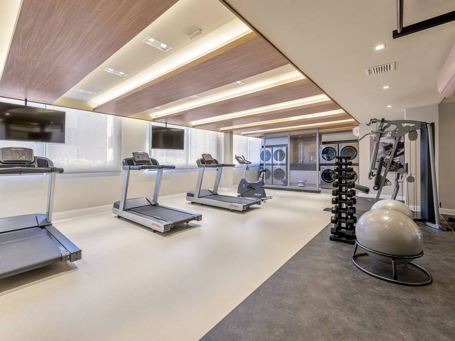 A modern gym with treadmills, a stationary bike, and a rowing machine.