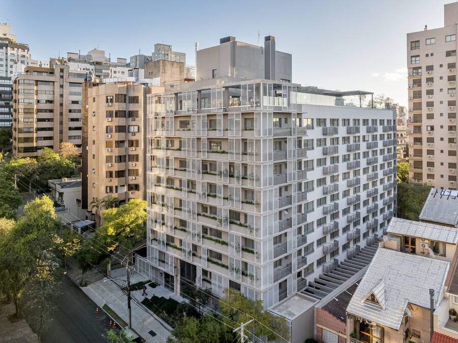 A modern multi-story building with a grid-like facade, balconies, and a mix of residential and commercial spaces.