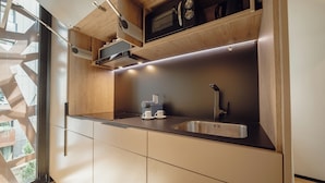 Een moderne keuken met een roestvrijstalen spoelbak, houten kastjes en een ingebouwde magnetron.
