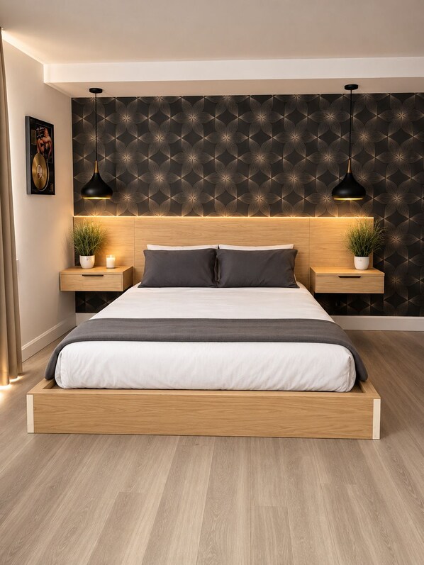 Un dormitorio moderno con estructura de cama de madera, dos mesitas de noche con lámparas, un papel tapiz estampado y un cuadro en la pared.