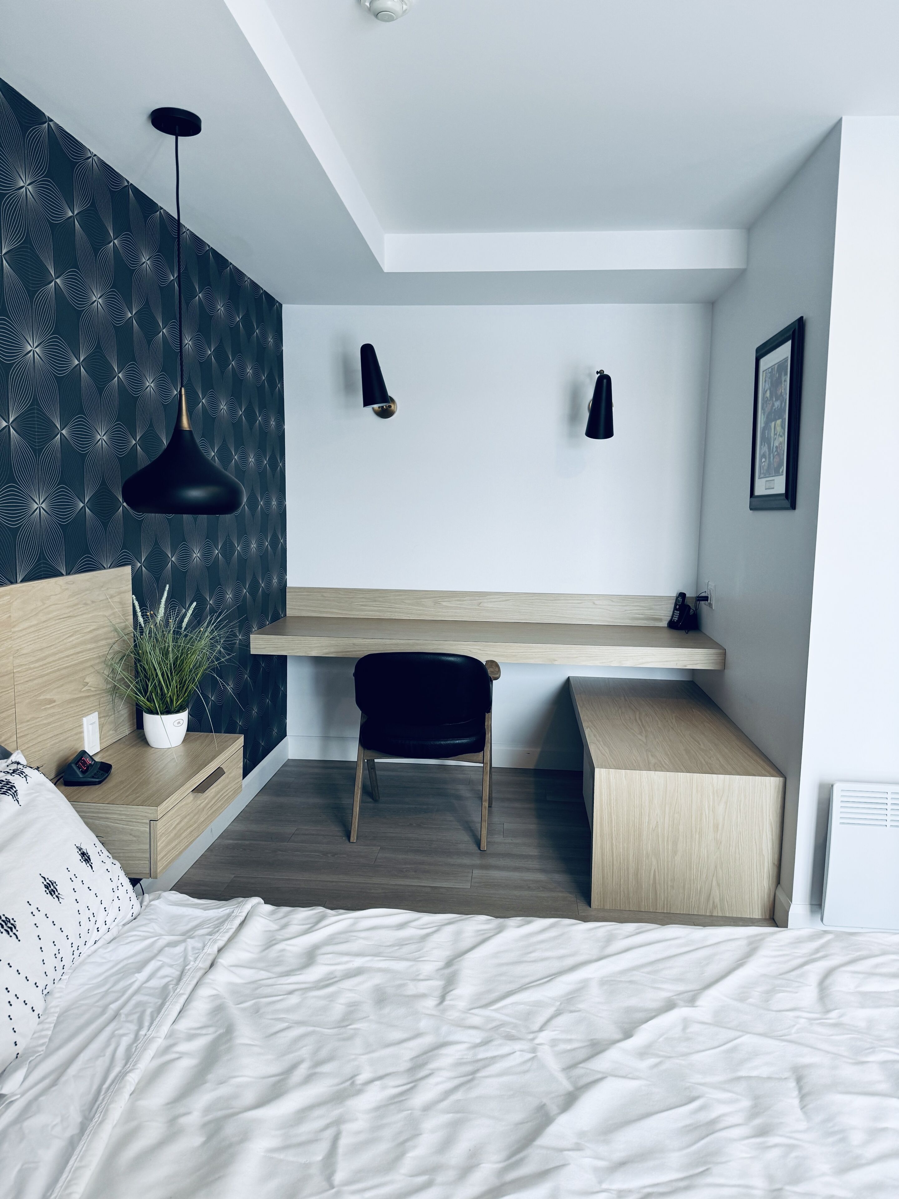 Une chambre à coucher moderne, comprenant un lit, une table de chevet, un bureau et une chaise.