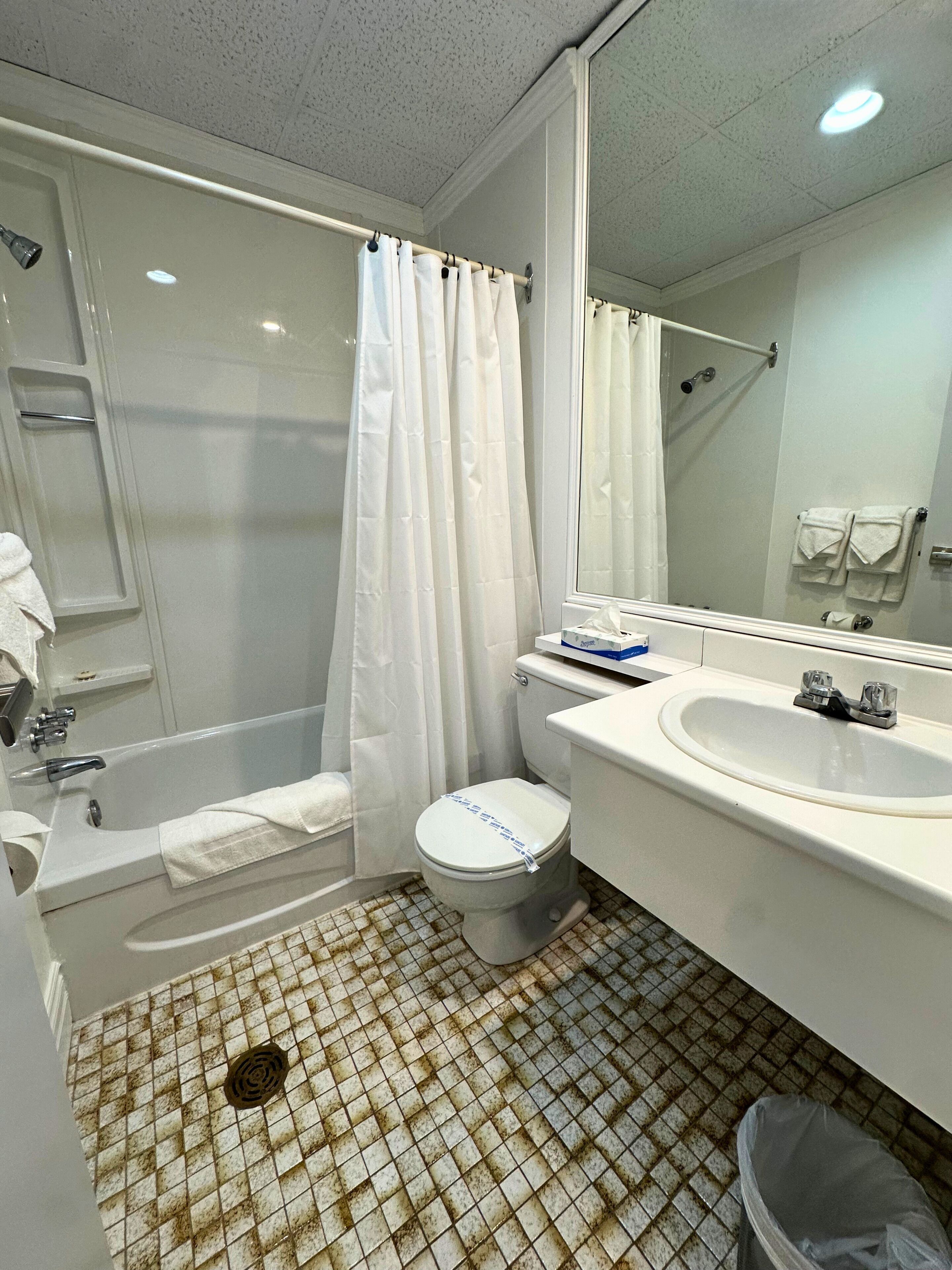 A bathroom with a bathtub, toilet, and sink.