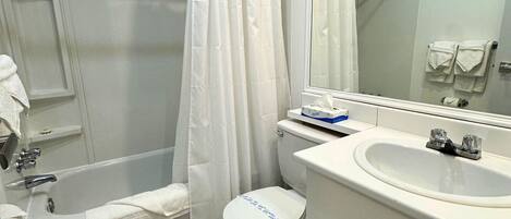 A bathroom with a bathtub, toilet, and sink.