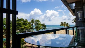 A glass table with a view of the ocean and palm trees. - Residencial Di Mare - by New Time  (Ipojuca)