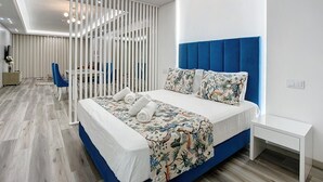 A modern bedroom with a large bed, a desk, and a chair. - Torre Palace II by Atlantic Holiday (Camara de Lobos)