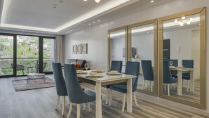 A modern dining area with a large table, blue chairs, and a large mirror. - Torre Palace II by Atlantic Holiday (Camara de Lobos)