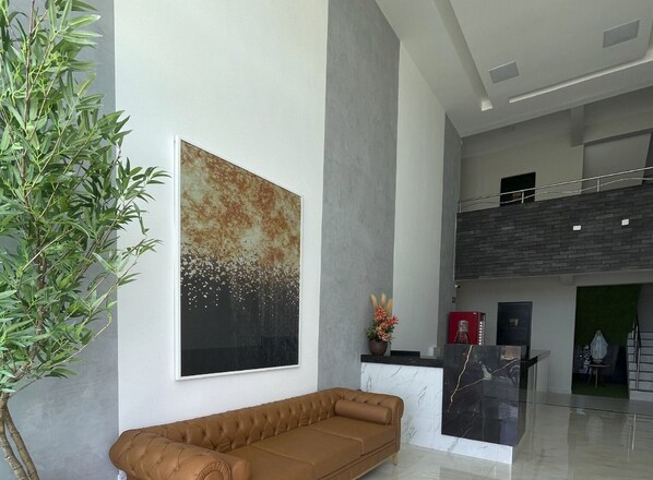 Um lobby moderno com uma grande pintura abstrata, um sofá estofado e um balcão de recepção.