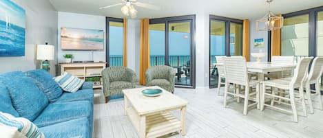 Ett vardagsrum med en soffa, stolar, ett bord och en takfläkt.