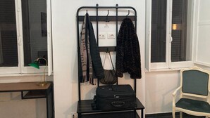 A room with a bed, a desk with a lamp, a wall-mounted rack with clothes, a chair, and a suitcase. - 3 Bagni , 3 Docce, 3 Stanze da Letto nel Centro di Roma (Roma)