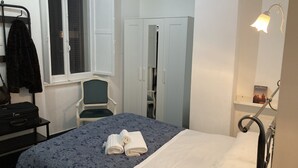 A bedroom with a bed, a chair, a wardrobe, a window, and a bedside lamp. - 3 Bagni , 3 Docce, 3 Stanze da Letto nel Centro di Roma (Roma)