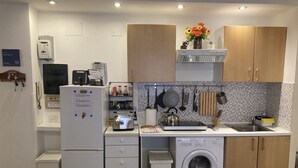 A compact kitchen with a refrigerator, washing machine, and a small countertop with a kettle and toaster. - 3 Bagni , 3 Docce, 3 Stanze da Letto nel Centro di Roma (Roma)
