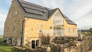 A stone building with a large window and a balcony. - Nook Cottage (Alnwick)