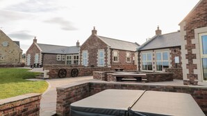 Un patio con edificios de ladrillo, mesas al aire libre y una mesa de billar.