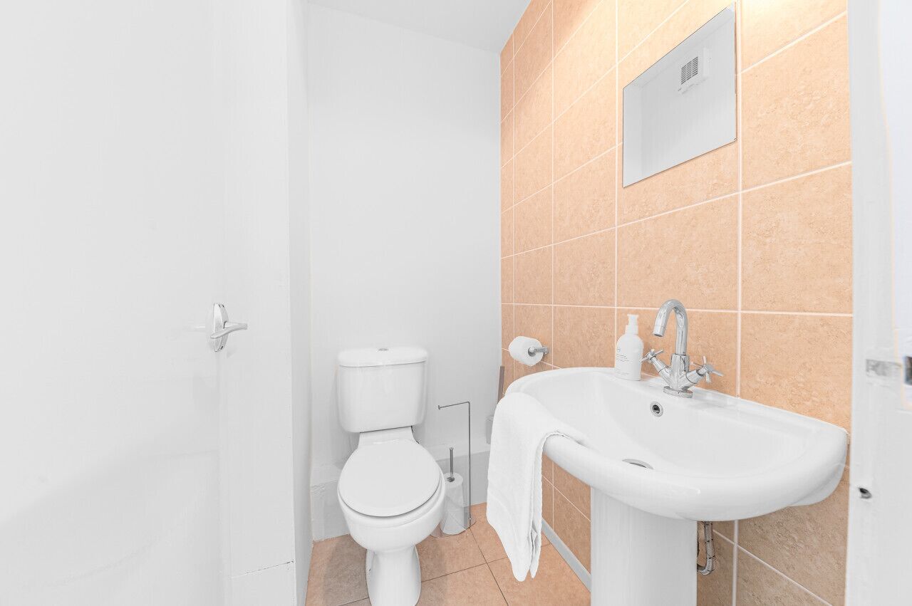 Un bagno con il water, un lavandino e un porta asciugamani.