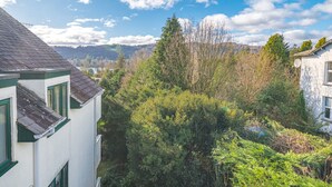 A residential area with houses, dense greenery, and a clear sky. - Two minute walk from the World of Beatrix Potter, apartment with parking (Bowness-on-Windermere)