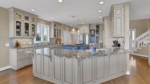 A spacious kitchen with a large island, built-in cabinets, and a central island with a sink. - Paradise Found: Waterfront Escape with Dock, Firepit, and Sunsets Galore! (Wrightsville Beach)