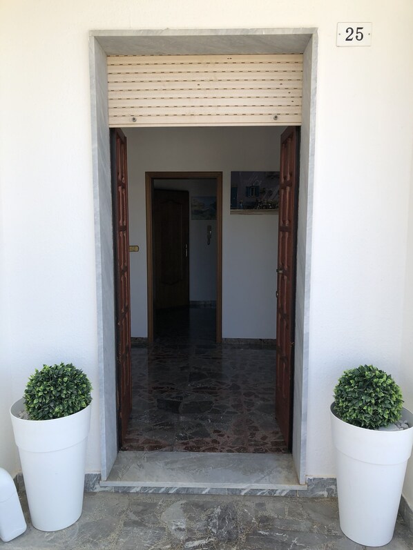A doorway with a tiled floor leading to an interior space.