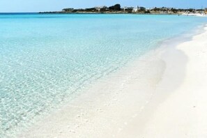 Una playa con agua turquesa cristalina y arena blanca.