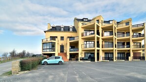 Un edificio residencial de varios pisos, con balcones y grandes ventanales.