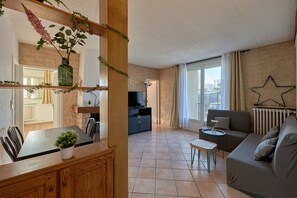 Un salon moderne comprenant un coin repas, un canapé, un téléviseur et une cheminée.