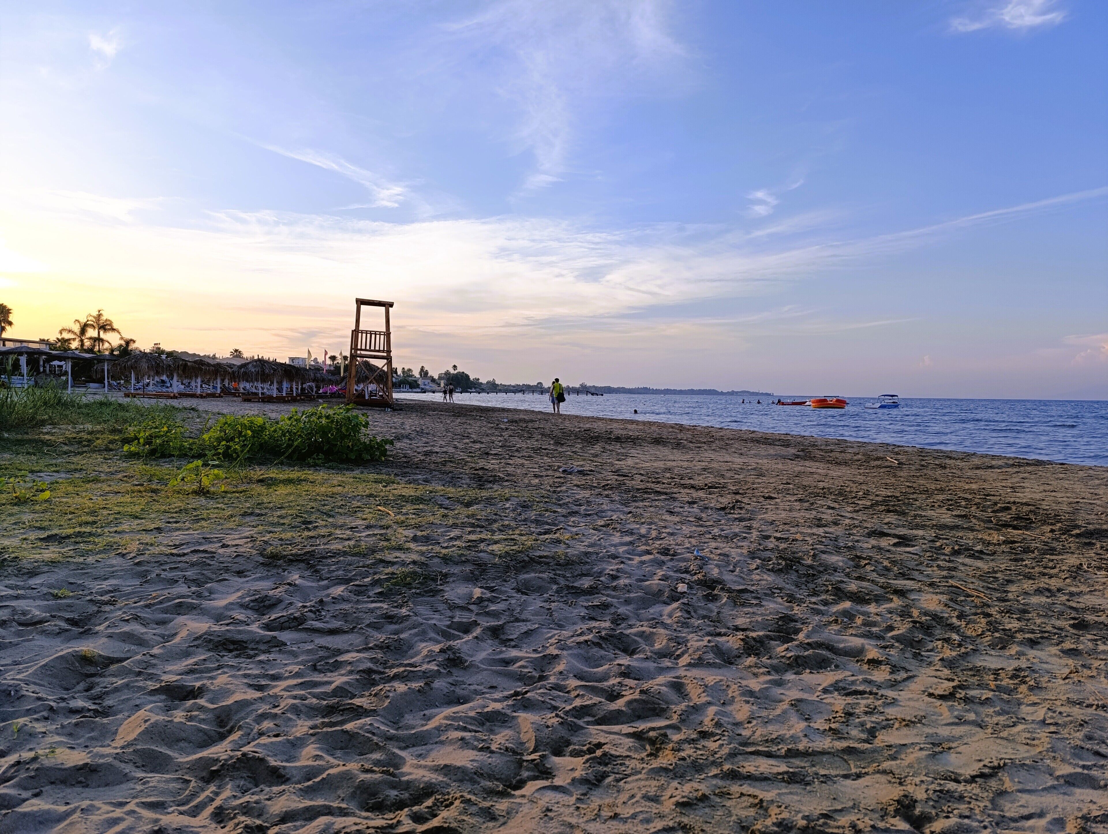 A beach with a wooden structure, possibly a lifeguard tower, and a clear sky.
