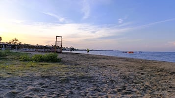 A beach with a wooden structure, possibly a lifeguard tower, and a clear sky.