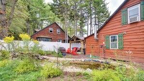 A rustic cabin with a small pond, surrounded by dense forest. - Rustic Log Cabin Near Jack Frost and Lake Harmony (Blakeslee)