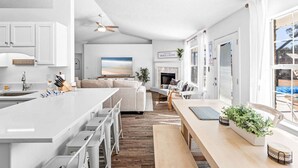 A spacious kitchen with a large island, white cabinetry, and a dining area with a wooden table and chairs. - Heated Pool | Minutes to Navarre Beach | 2 Kings (Navarre)
