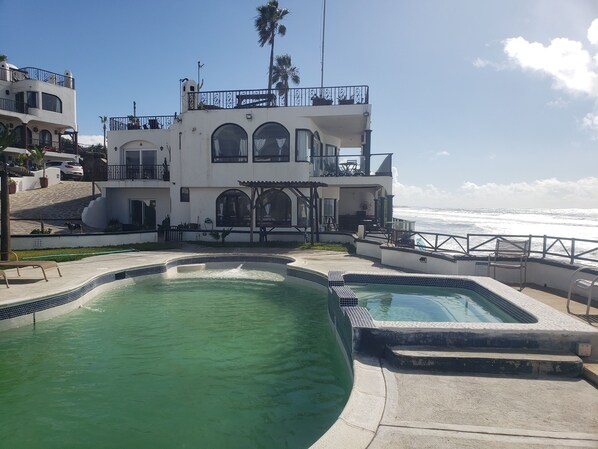 Una casa de dos pisos con piscina y vista al océano.