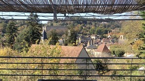 Vista da un balcone con una pergola in legno, su un borgo caratterizzato da edifici tradizionali e una chiesa imponente.