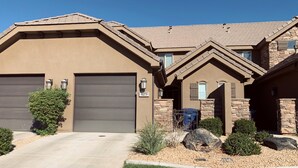 A two-story house with a garage, stone facade, and a well-maintained lawn. - Spacious, Clean Coral Ridge Townhome (Washington)